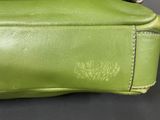 an image of a close up of a green purse on a table