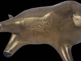 brass statue of a pig on a black background with the word free hugs written on it