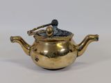 a small brass teapot with a handle on it