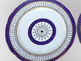 two plates with blue and white designs on them on a white surface