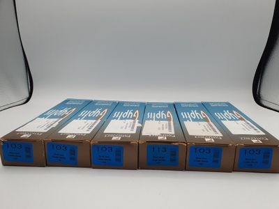 quatre boîtes de pellicule bleue et blanche posées sur une table blanche