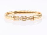 un bracelet rigide en or jaune serti de diamants sur fond blanc