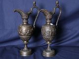 paire de vases anciens en laiton sur un socle, sur fond bleu
