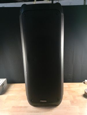 une photo d'une enceinte noire posée sur une table en bois