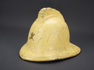 un vieux casque jaune orné d'un oiseau sur fond noir