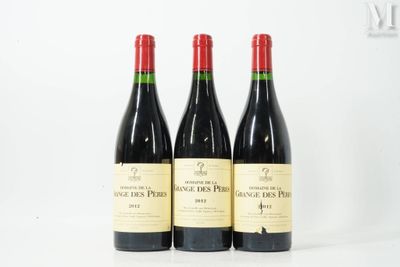 three bottles of red wine sitting next to each other on a table
