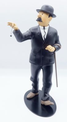 une figurine représentant un homme en costume et chapeau, muni d'une canne