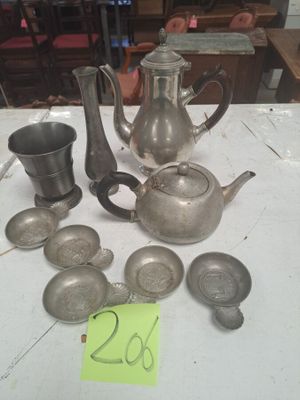 de nombreux objets en argent posés sur une table, accompagnés d'une étiquette de prix