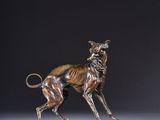 a bronze statue of a dog standing on a base
