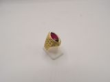 gros plan d'une bague en or avec une pierre rouge