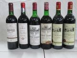 six bottles of wine are lined up in a row on a table
