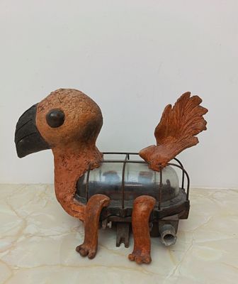 statue of a bird with a cage on its back sitting on a table
