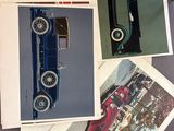 several old photos of old cars are displayed on a table