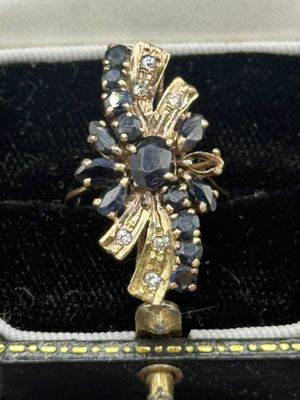 an image of a gold ring with black and white stones in it