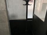 a coat rack in the corner of a room next to a door