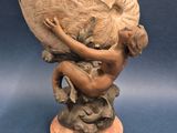 statue d'une femme tenant un éventail, posée sur un socle en bois