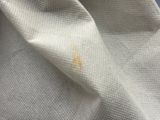 a close up of a white shirt with a yellow spot on it