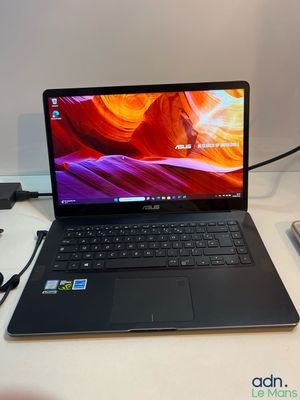 un ordinateur portable posé sur un bureau avec un chargeur