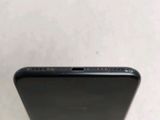 the back of a black cell phone sitting on top of a table