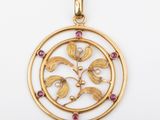 a gold and ruby pendant with a circular design