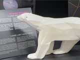 a white bear figurine on a table next to a book