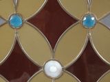 a close up of a stained glass window with a flower design