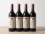trois bouteilles de vin rouge posées sur une table en bois