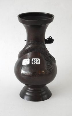 a brown vase with a bird on it sitting on a table