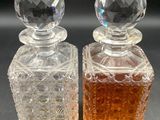pair of clear glass perfume bottles sitting on top of a black surface