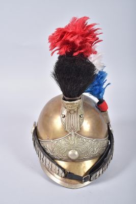 un casque doré orné de plumes rouges et bleues