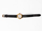 an image of a watch on a black strap on a white surface