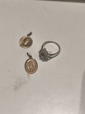 deux bagues et une pièce de monnaie sont posées sur une surface blanche