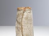 un vase blanc surmonté d'un couvercle marron, posé sur une table