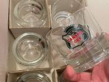 une personne tenant un verre devant une boîte de verres vides