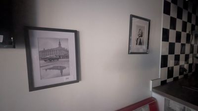une photo d'un salon avec un canapé et des tableaux accrochés au mur