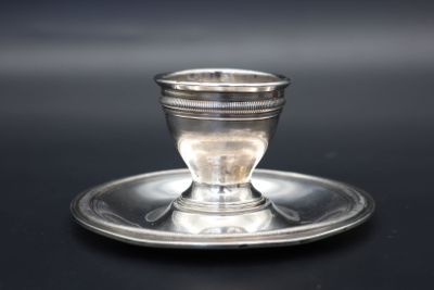 une tasse et une soucoupe en argent posées sur un plateau en argent