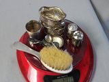 a red scale with a brush, spoon, and other items on it