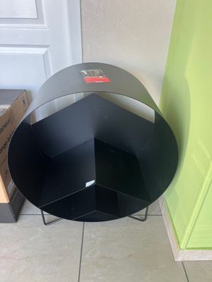 une table noire avec un piètement en métal et une porte verte
