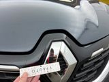 a person that is holding a sticker in front of a car