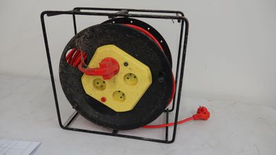 a close up of a black and yellow wire reel with a red cord