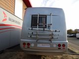 a silver bus that is parked in front of a building