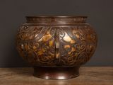 a brown vase sitting on a table with a black background