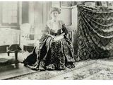 a black and white photo of a woman sitting in a chair
