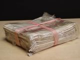 a stack of papers wrapped in plastic with a pink ribbon