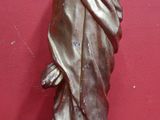 une statue représentant un homme vêtu d'une cape, posée sur une table