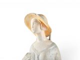 a figurine of a woman with a hat on her head