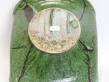 a green vase with a picture on it