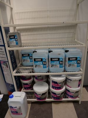 plusieurs bidons de produits d'entretien sur une étagère dans un magasin