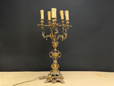 un candélabre ancien en laiton à cinq bougies posé sur une table