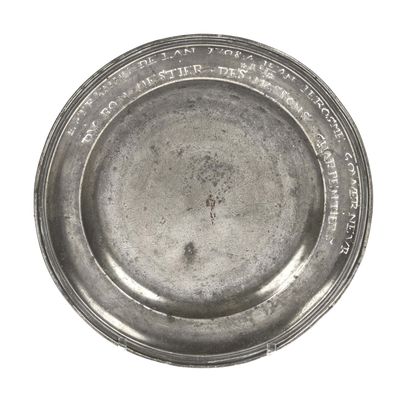 a silver plate with writing on it on a white surface